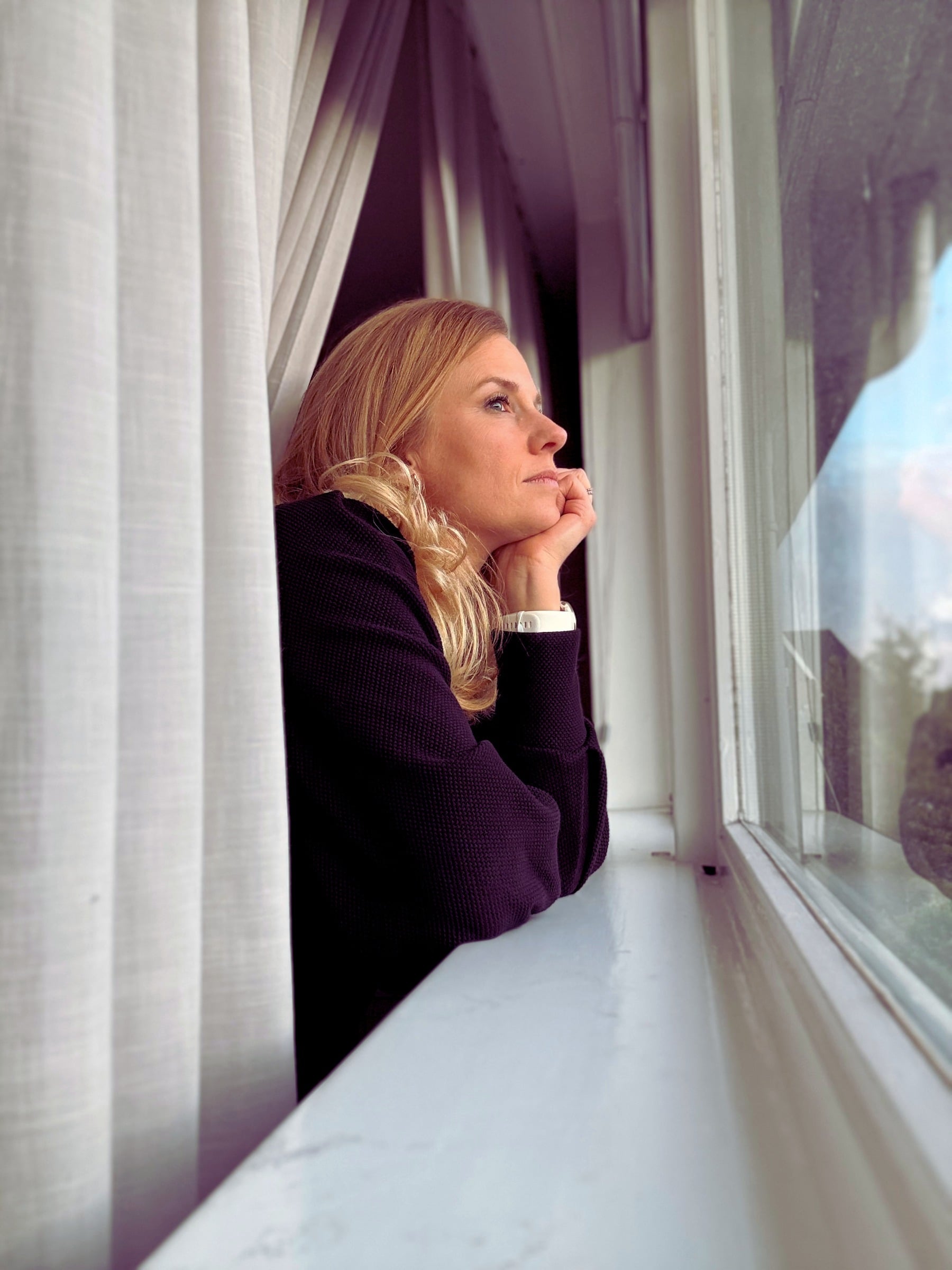 Erika Vos kijkt door het raam, in gedachten